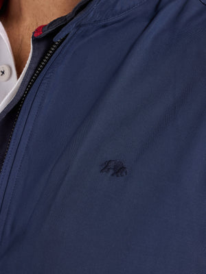 Close-up of a navy blue jacket with a brand logo on the chest.