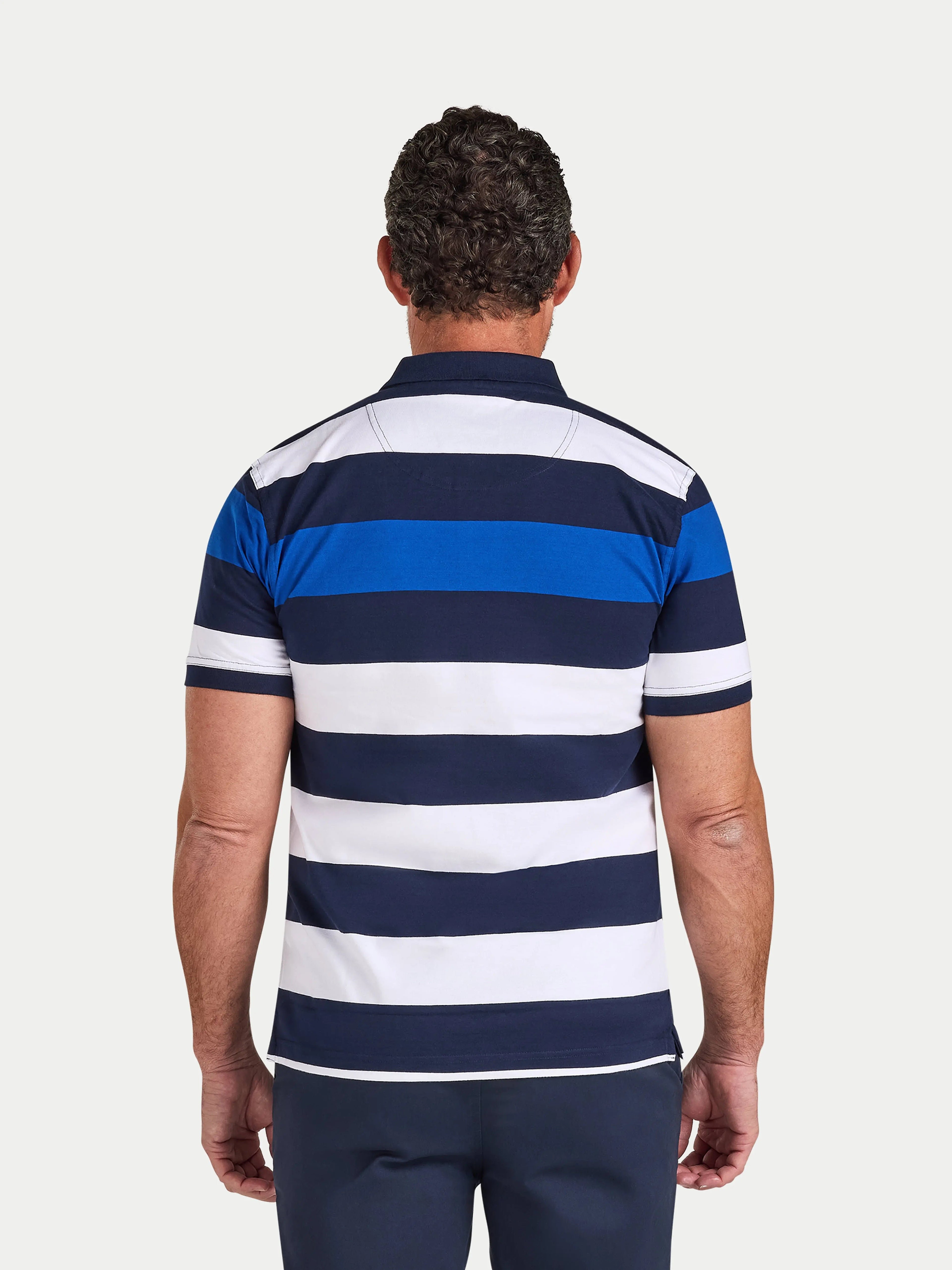 Man wearing a blue and white striped polo shirt on a light gray background