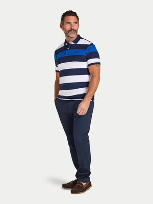 Man wearing a blue and white striped polo shirt and navy pants on a white background