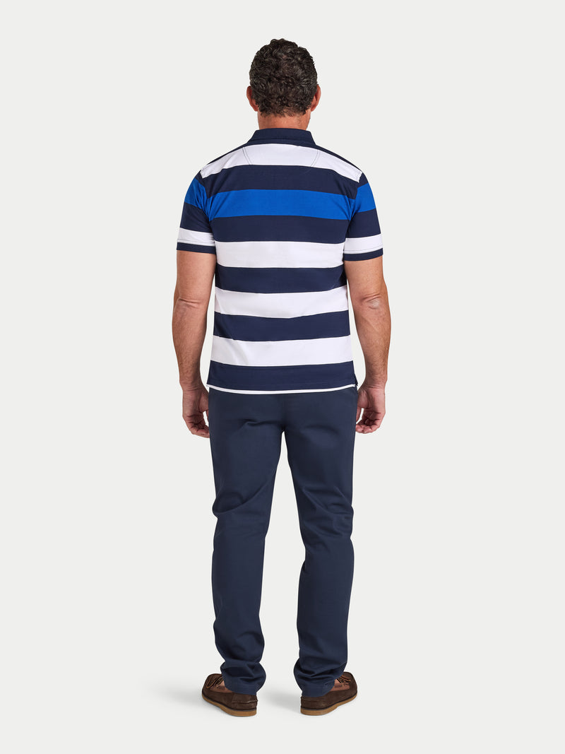 Man wearing a blue and white striped polo shirt and navy pants on a white background