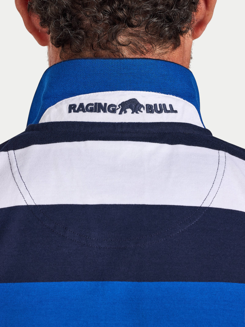 Close-up of a person wearing a blue and white striped shirt with 'Raging Bull' logo.
