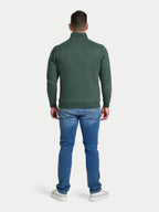 Man wearing a green sweater and blue jeans on a white background