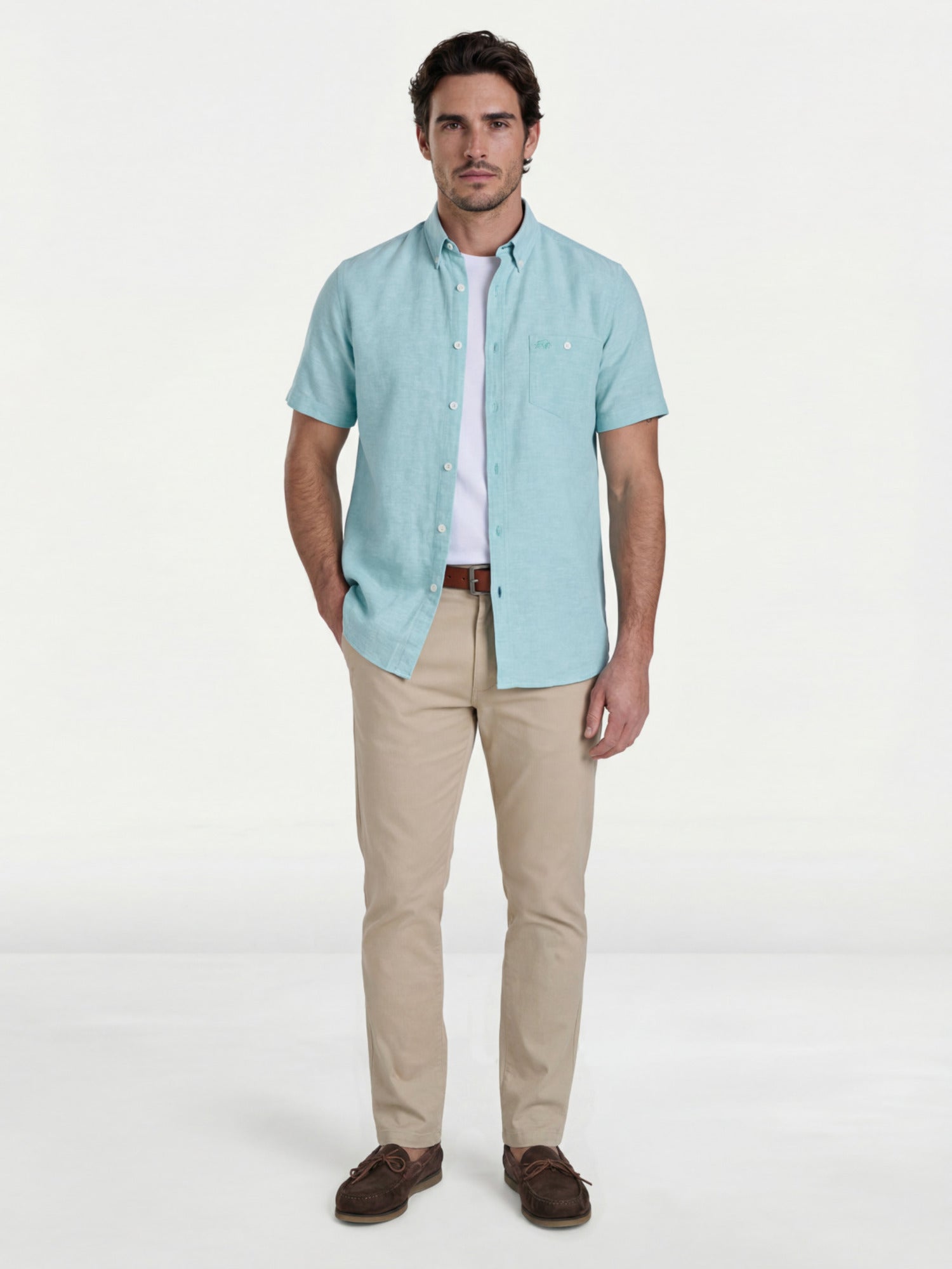 Man wearing a light apple green shirt, beige trousers, and brown shoes on a white background