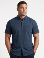Man wearing a blue short-sleeve shirt on a white background