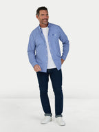 Man wearing a blue checkered shirt, white t-shirt, and dark jeans on a white background