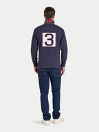 Man wearing a navy blue long-sleeve shirt with a large number '3' on the back, standing against a white background.