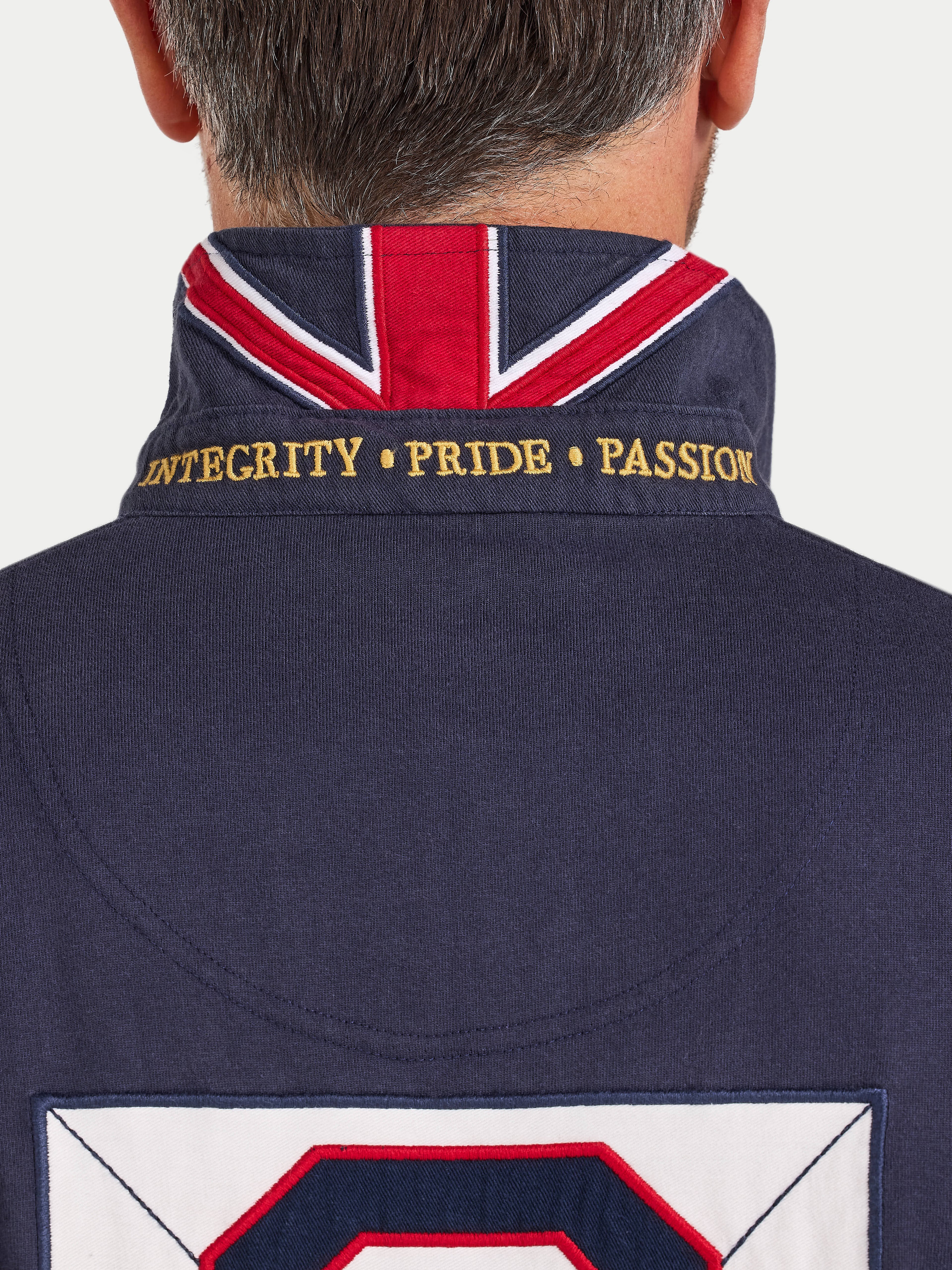 Navy jacket with Union Jack design and embroidered text on a plain background