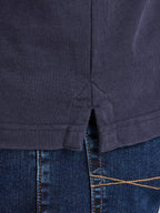 Close-up of a navy blue shirt and blue jeans with stitching details.
