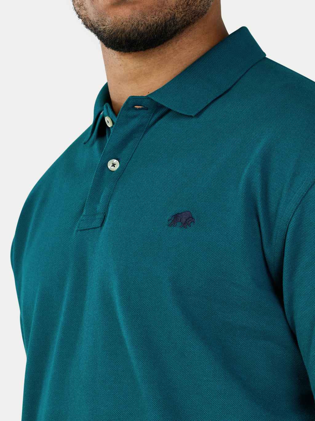 Teal polo shirt with a small logo on a white background