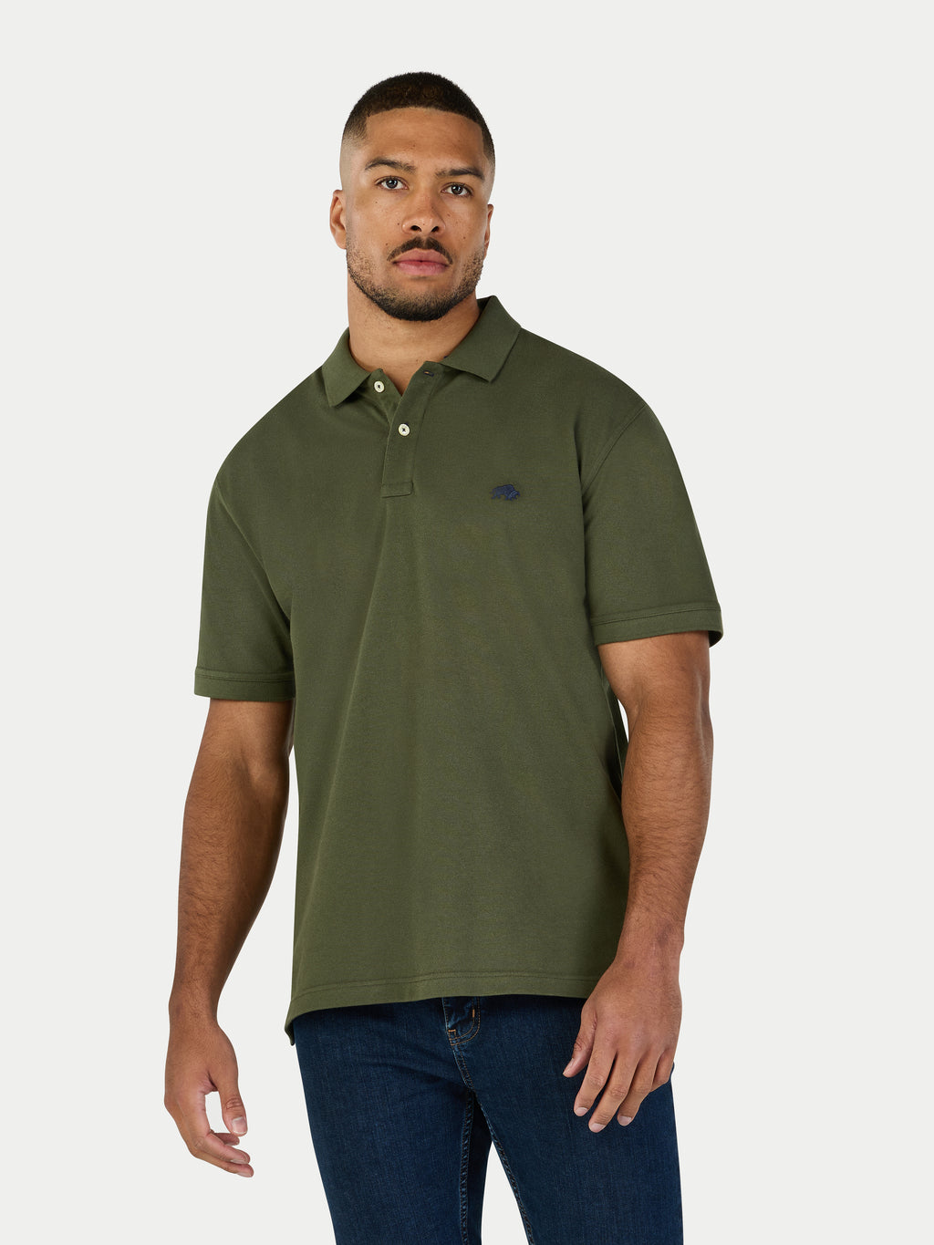 Man wearing a green polo shirt and blue jeans on a white background