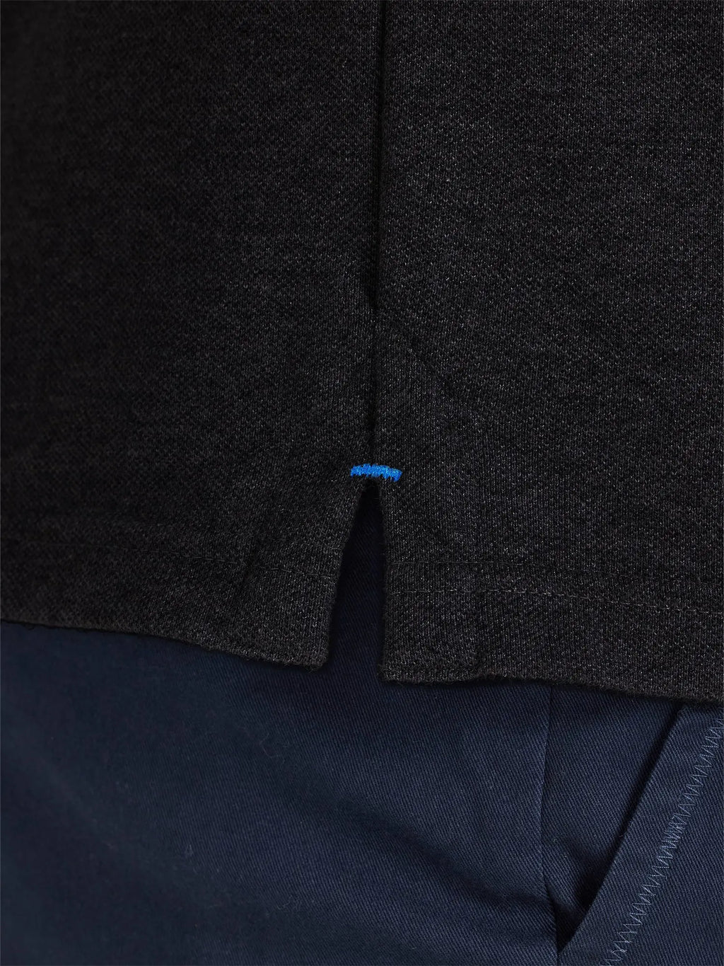 Dark gray textured fabric with a blue tag on a dark background