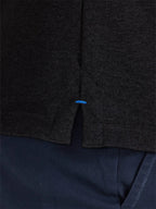 Dark gray textured fabric with a blue tag on a dark background