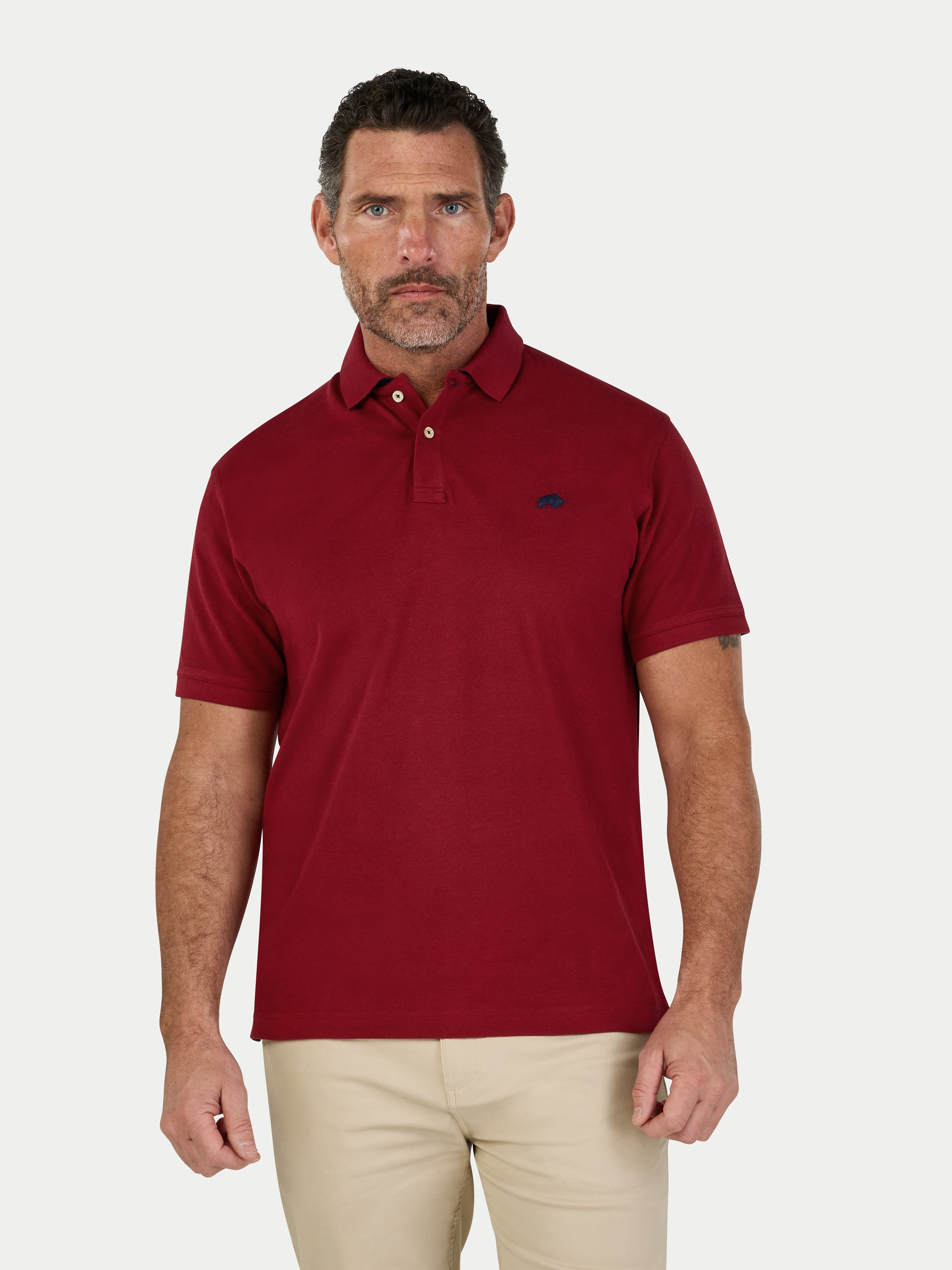 Man wearing a red polo on white background. 