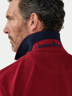 Man wearing a red jacket with 'Raging Bull' logo on a white background.
