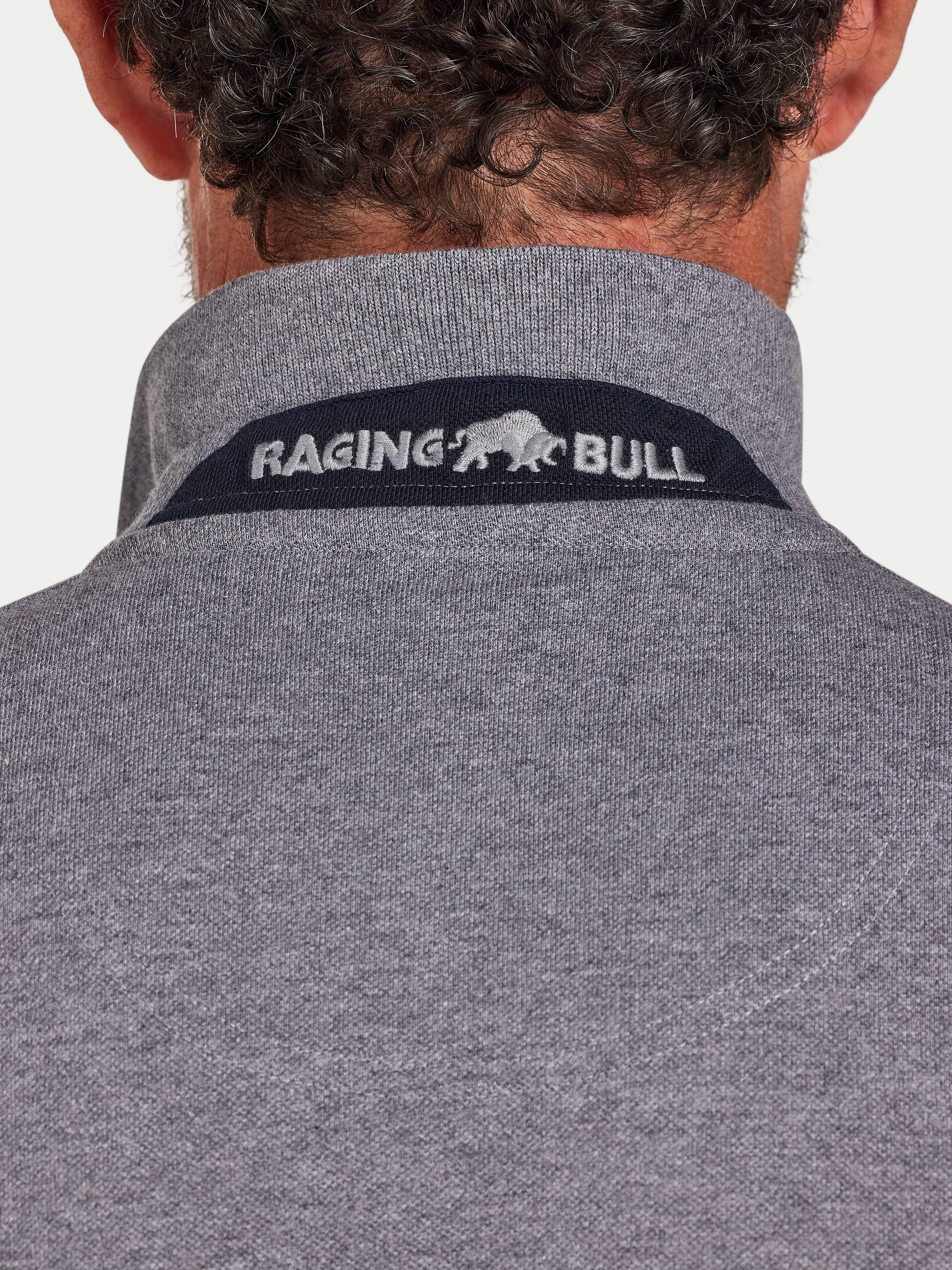 Gray fleece jacket with Raging Bull logo on the collar against a white background