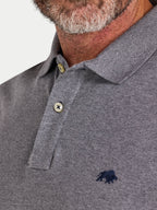 Close-up of a gray polo shirt with a logo on a light gray background