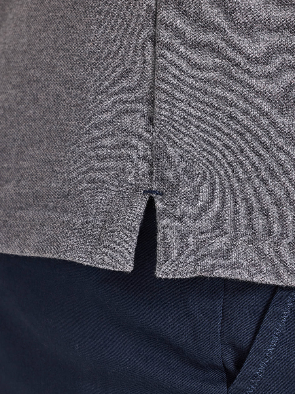 Close-up of a gray textured fabric with a zipper, on a dark background.
