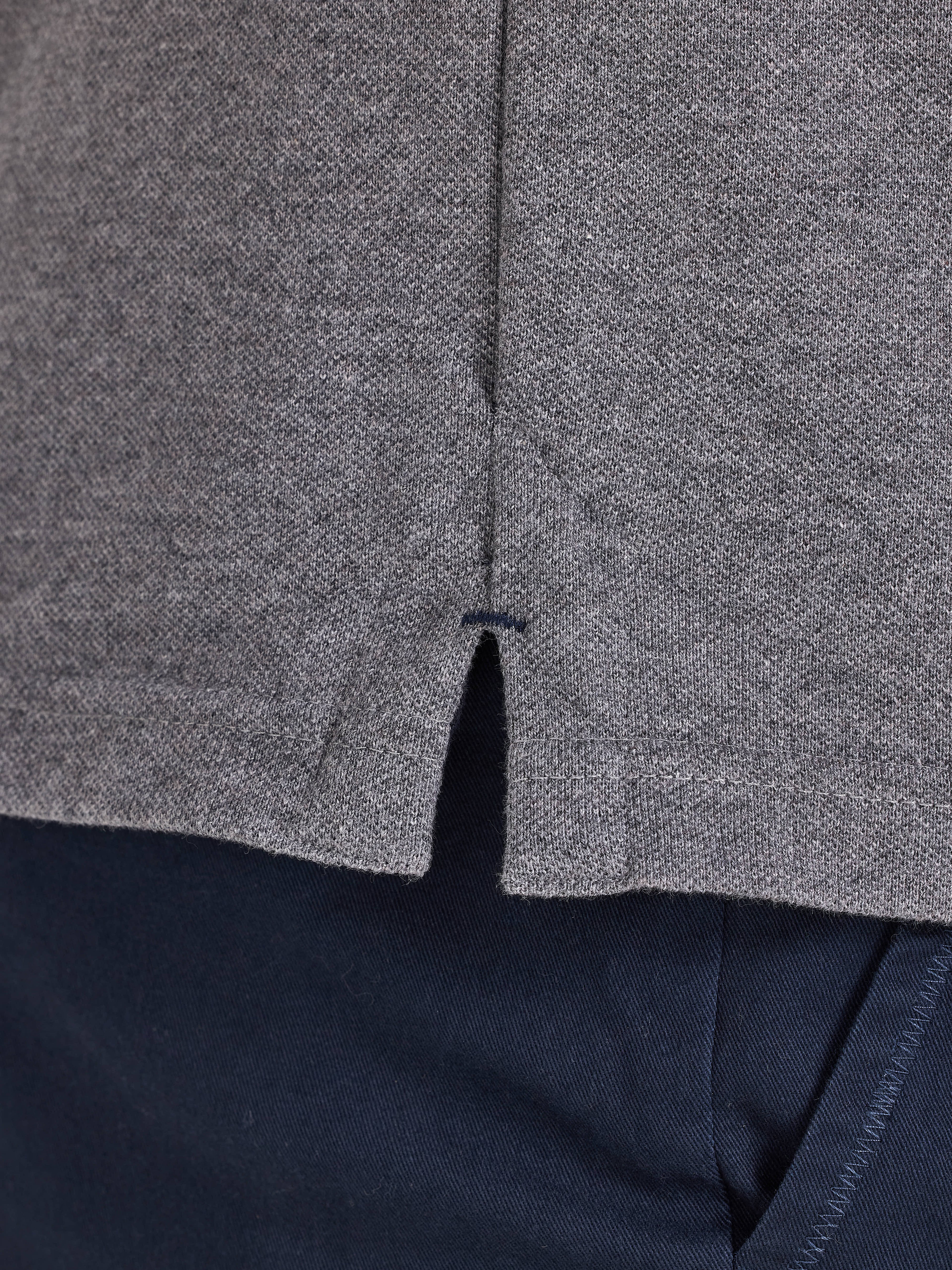 Close-up of a gray textured fabric with a zipper, on a dark background.