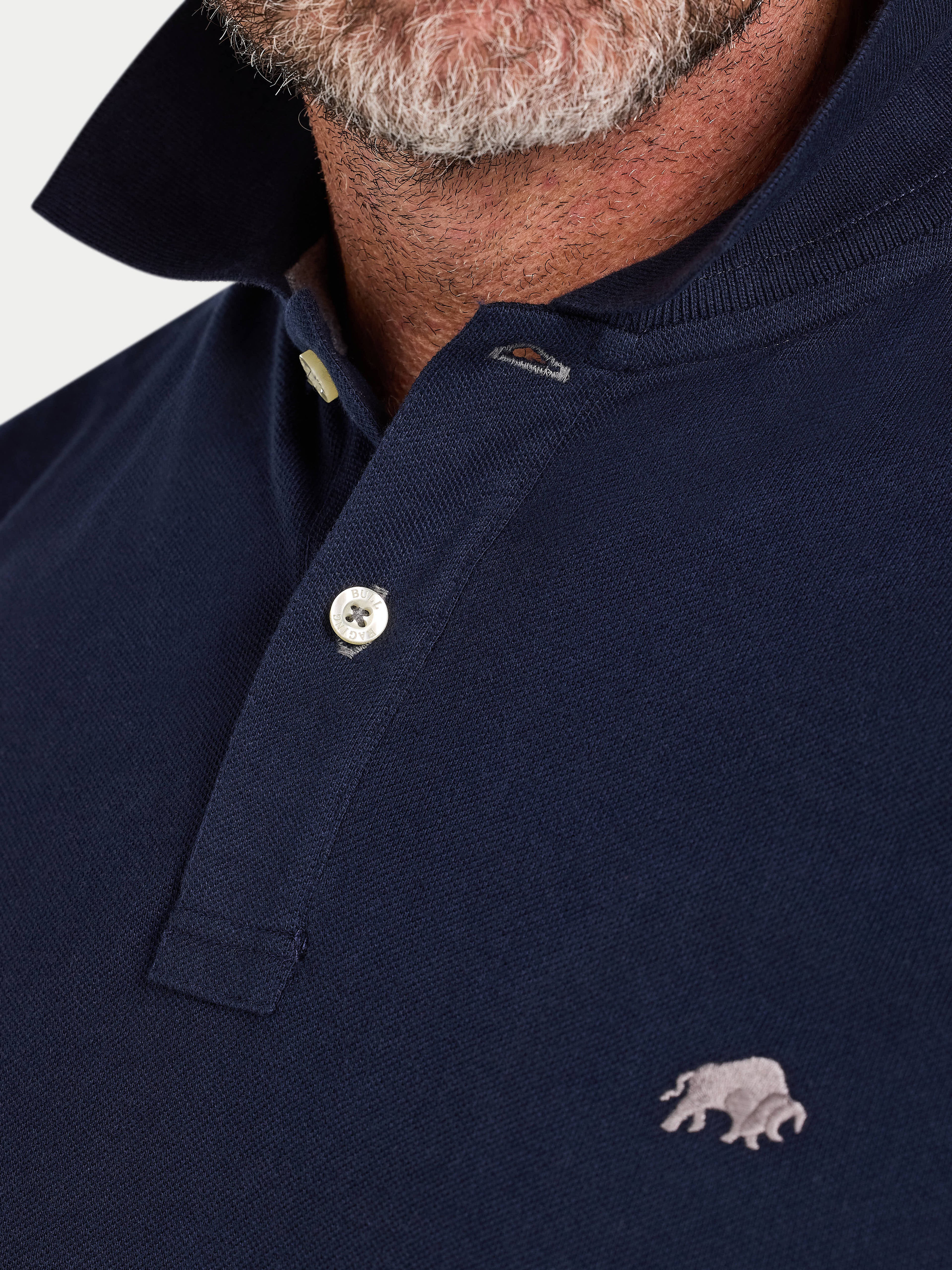Navy blue polo shirt with a small bear emblem on a white background