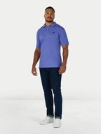Man wearing a purple polo shirt and dark jeans on a white background
