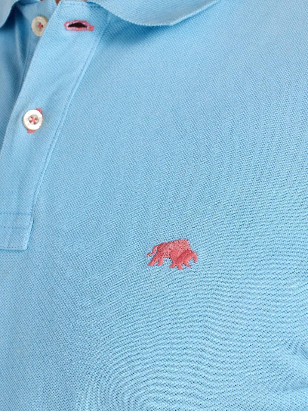 Light blue polo shirt with a pink logo on a plain background