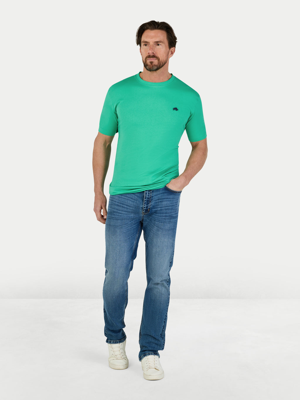 Man wearing a green t-shirt and blue jeans on a white background