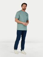 Man wearing a green t-shirt and blue pants on a white background