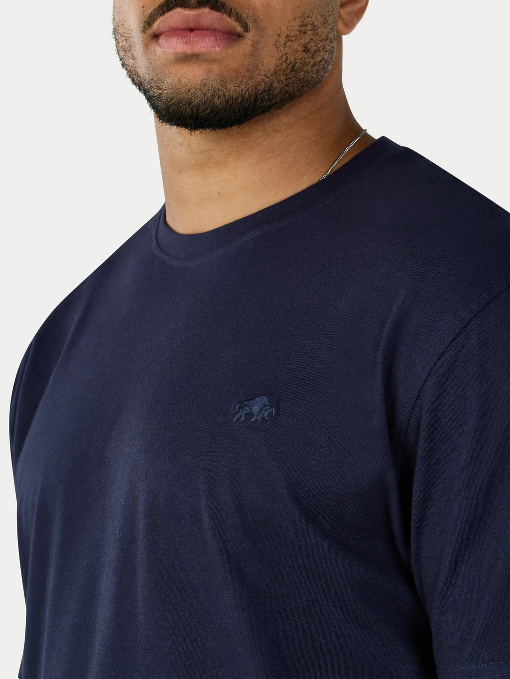 Navy blue t-shirt with a small logo on a plain background