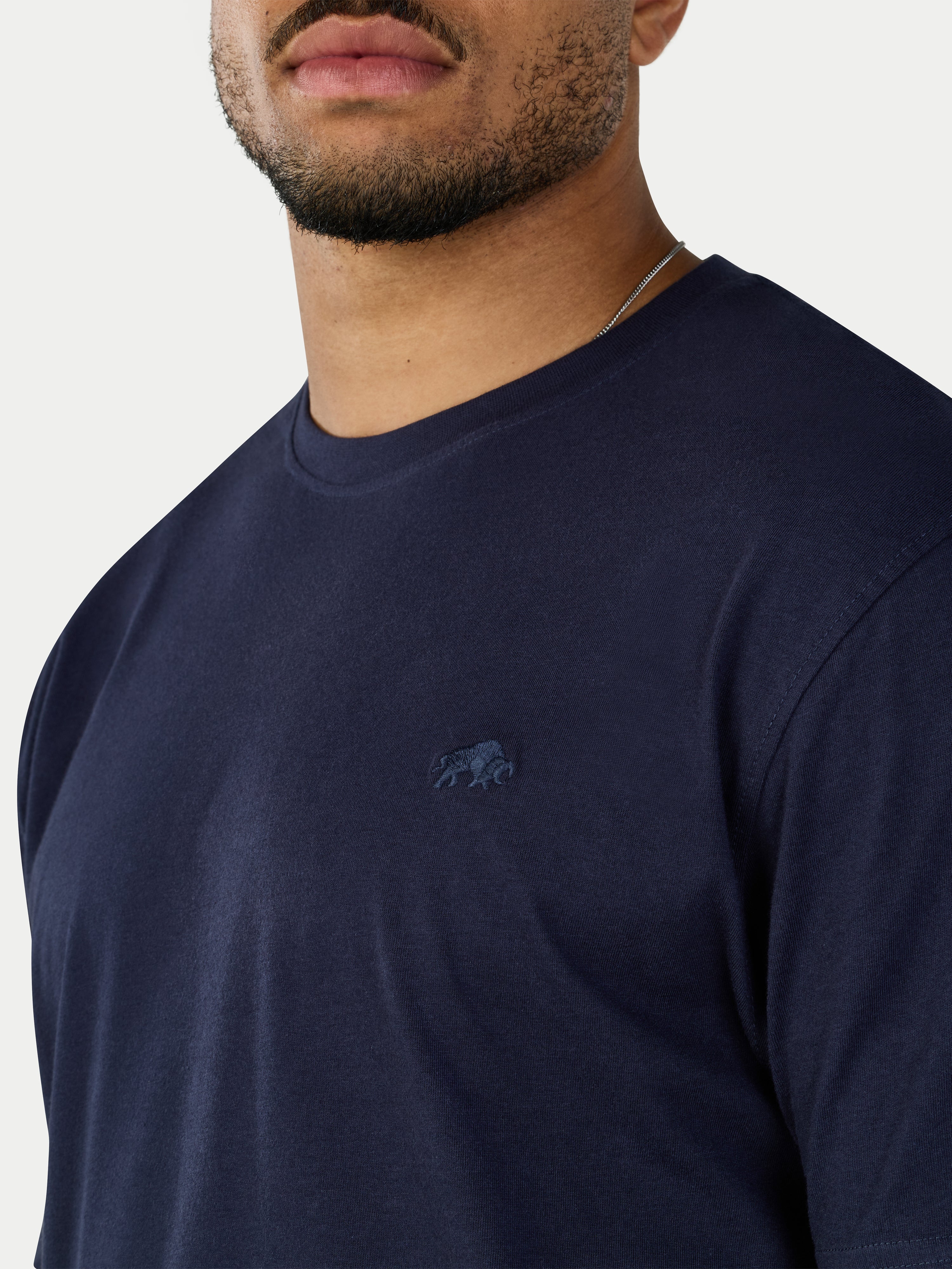 Navy blue t-shirt with a small logo on a plain background