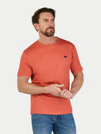 Man wearing an orange t-shirt with a logo on a white background