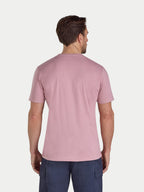Man wearing a pink t-shirt and navy pants on a white background