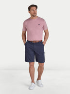 Man wearing a pink t-shirt and navy cargo shorts on a white background
