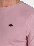 Close-up of a pink t-shirt with a black logo on a light gray background
