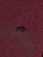 Close-up of a maroon fabric with a black bear emblem.