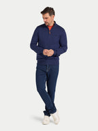 Man wearing a navy sweater and jeans on a white background