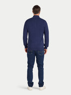 Man wearing a blue long-sleeve shirt and jeans on a white background
