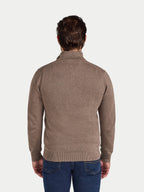 Man wearing a brown sweater and blue jeans on a white background