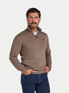 Man wearing a brown sweater and blue jeans on a white background