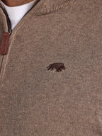 Close-up of a brown sweater with a small logo on the chest.
