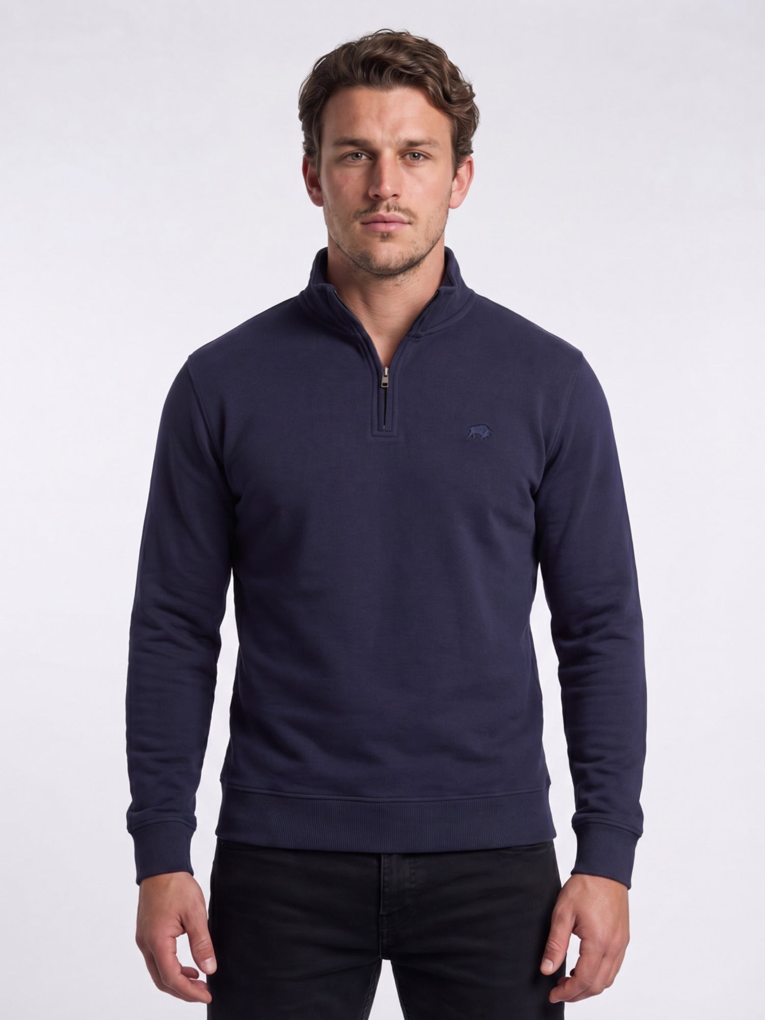 Man wearing a navy blue pullover with a quarter zip on a white background