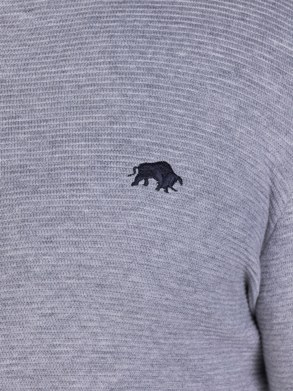 Close-up image of black Raging Bull logo on grey sweater.