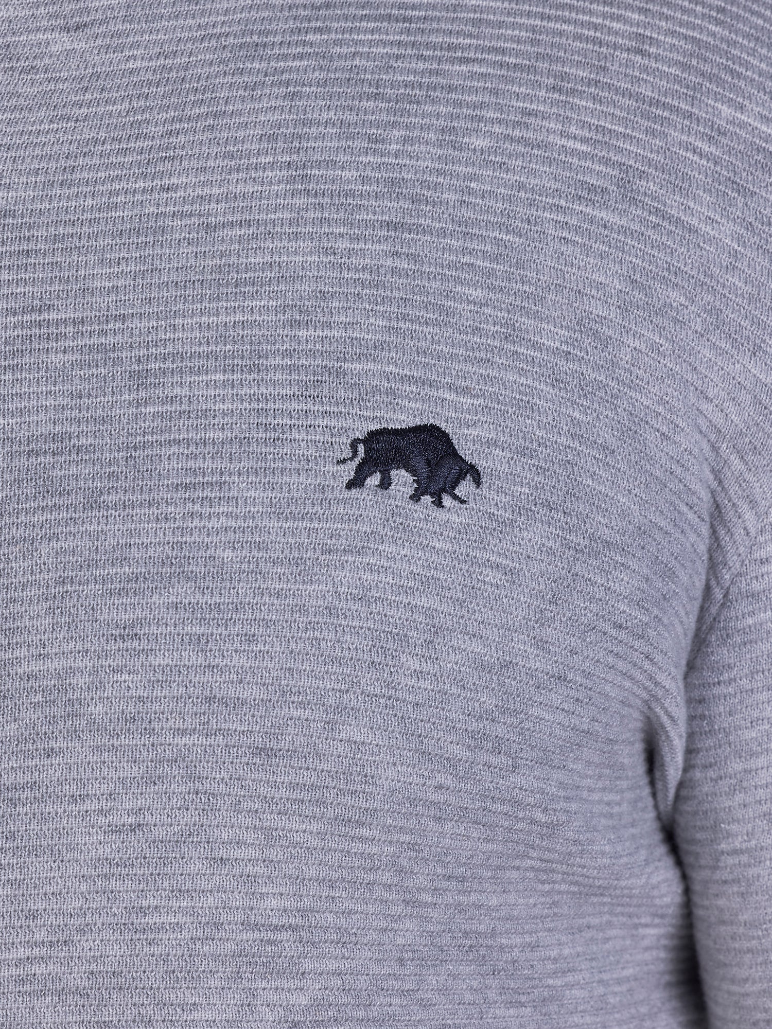 Close-up image of black Raging Bull logo on grey sweater.