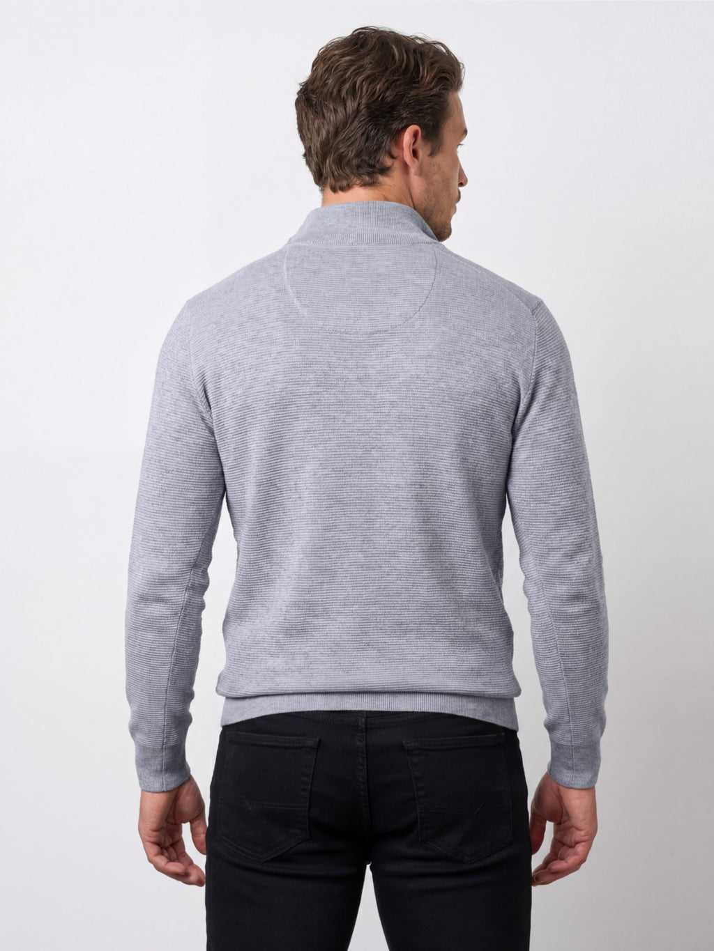 Man wearing a gray sweater and black pants on a white background