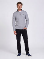 Man wearing a gray sweater and black pants on a white background