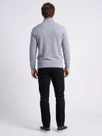 Man wearing a gray sweater and black trousers on a white background