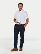 Man wearing a white shirt, navy pants, and brown shoes on a white background