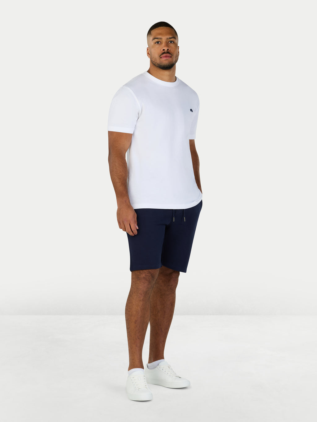 Man wearing a white t-shirt and navy shorts on a white background