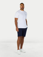 Man wearing a white t-shirt and navy shorts on a white background