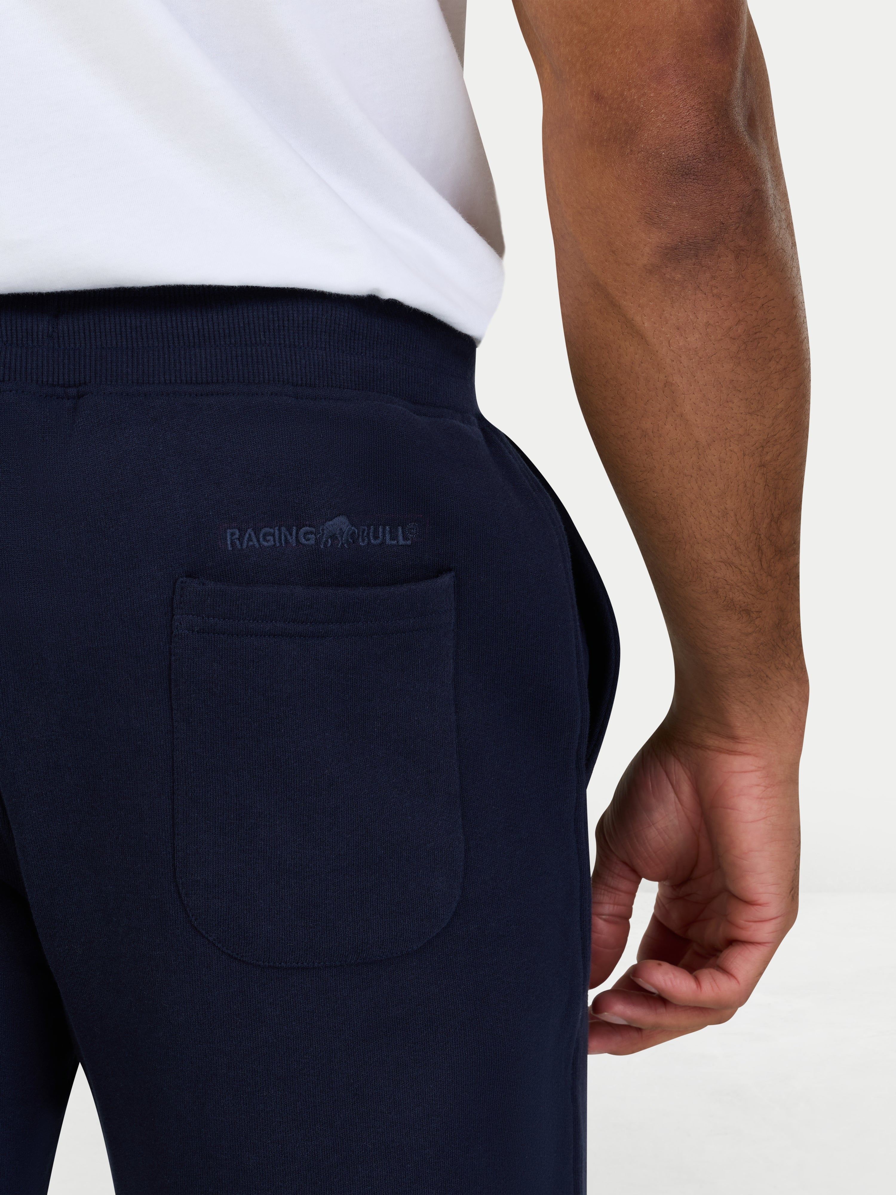 Navy jogger pants with Raging Bull logo on the pocket against a white background