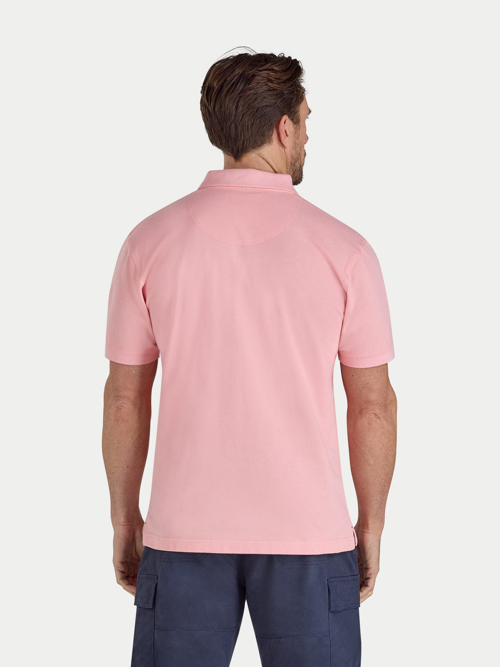 Man wearing a pink polo shirt on a white background